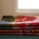 A stack of folded batik fabrics featuring intricate floral and paisley patterns